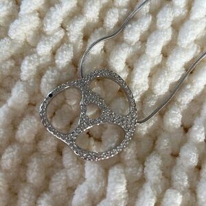 Pretzel shaped pendant with crystals.